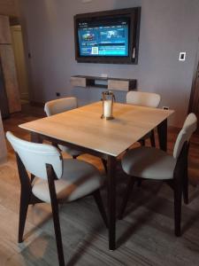 a wooden table with chairs and a television on a wall at Cabañas Juan Pedro in Los Molles