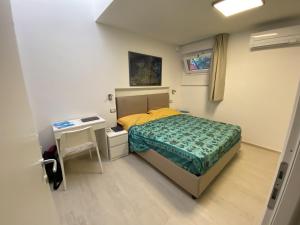 ein kleines Schlafzimmer mit einem Bett und einem Schreibtisch in der Unterkunft Villetta Corallo IUN Q1810 in Porto Pollo