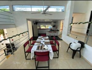 a dining room with tables and red chairs in a restaurant at LA FLORESTA ISLA DEL SoL in Prado