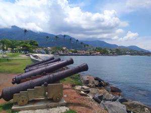 圣塞巴斯蒂安Sobrado Refúgio do Mar - Aconchego e Conforto perto das Praias的一组大炮摆放在水体旁边。