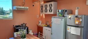 a kitchen with a refrigerator and a table in it at Hospedaje La ruta Los Angeles in Los Ángeles