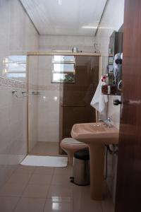 a bathroom with a shower and a toilet and a sink at Apart Hotel Água Limpa in Prados