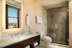 a bathroom with a sink and a toilet and a window at The Liberty Trust in Roanoke