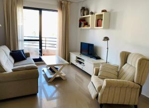 a living room with two couches and a television at Regia Bahia en Cabo Roig in Orihuela Costa