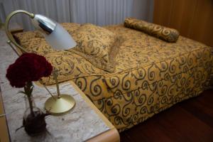 a bedroom with a bed with a lamp and a table at Apart Hotel Água Limpa in Prados