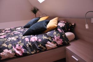 a bed with a flowered blanket and pillows on it at Vakantiehuisje Opdekamp in Merselo