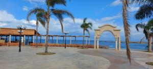 Al Minyah的住宿－Aquarius Touristic Resort，棕榈树和海洋凉亭