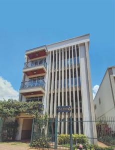 a tall building with a fence in front of it at Apart Hotel Água Limpa in Prados