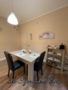 - une salle à manger avec une table et deux chaises dans l'établissement La Pigna dell'Etna, à Nicolosi