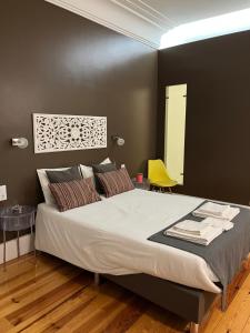 1 dormitorio con 1 cama grande y 1 silla amarilla en GoodTime Marquês Suites en Lisboa