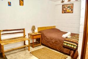 バーニョスにあるCentro Ecoturístico Alpinarのベッドルーム1室(ベッド1台、椅子、テーブル付)
