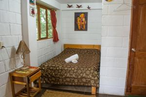 a small bedroom with a bed and a table at Centro Ecoturístico Alpinar in Baños