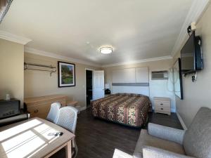 een hotelkamer met een bed en een woonkamer bij Flamingo Motel Oxnard in Oxnard