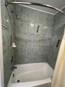 a white bath tub in a bathroom with a shower at Flamingo Motel Oxnard in Oxnard