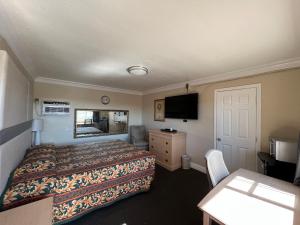 a hotel room with a bed and a television at Flamingo Motel Oxnard in Oxnard