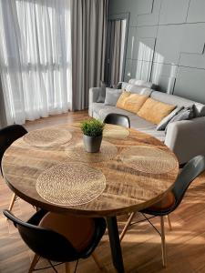 ein Wohnzimmer mit einem Holztisch und einem Sofa in der Unterkunft Horyzont Luksusowe apartamenty nad morzem z parkingiem in Misdroy