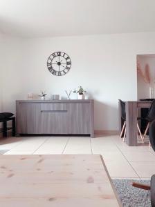 uma sala de estar com um relógio na parede em Maison La demoiselle de Chambord em Huisseau-sur-Cosson