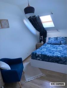 um quarto com uma cama azul e uma cadeira azul em Maison La demoiselle de Chambord em Huisseau-sur-Cosson