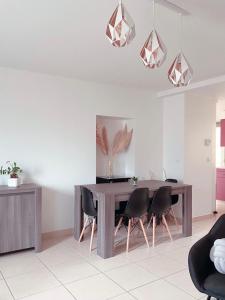 a dining room with a wooden table and black chairs at Maison La demoiselle de Chambord in Huisseau-sur-Cosson