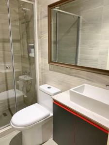a bathroom with a toilet and a sink and a shower at Plaza Oz - Av Alemania in Temuco +44 photos