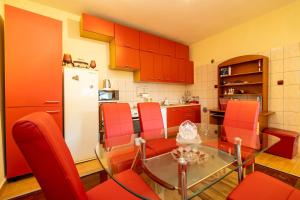 eine Küche mit einem Glastisch und roten Stühlen in der Unterkunft Apartman JOZIC in Knin