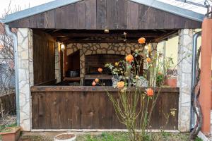 - un bâtiment doté d'une porte en bois avec des fleurs dans l'établissement Apartman JOZIC, à Knin