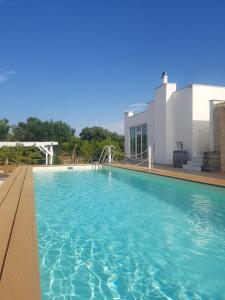 a large swimming pool in front of a house at Apulia Home in Carovigno