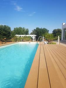 a large swimming pool with a volley ball net at Apulia Home in Carovigno