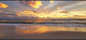 a sunset on a beach with the ocean at Naples Dream at WTC with Heated Pool SPA Sauna 7 bicycles and 3 mls to beach in Naples