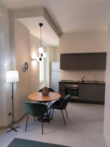 a kitchen with a table and chairs and a refrigerator at the 6 apartments in Rimini