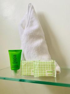 a pile of towels and a measuring cup on a shelf at Hotel Ana Mary in Santiago
