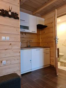 a kitchen with white cabinets and a sink at Apartamenty Pod Skałką in Szaflary