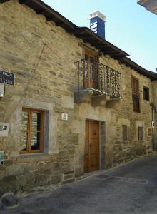 Casa Rural Los Cabritos de Tomás في بويبلا ذي سانابريا: مبنى حجري قديم مع باب خشبي وشرفة