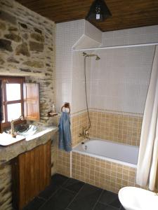 a bathroom with a bath tub and a sink at Casa Rural Los Cabritos de Tomás in Puebla de Sanabria