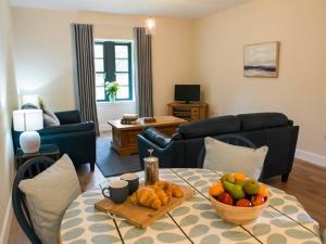 a living room with a table with a bowl of fruit on it at Stunning Edinburgh 1820s stables converted studio in Edinburgh