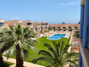 a view of a courtyard with a pool and palm trees at Regia Bahia en Cabo Roig in Orihuela Costa