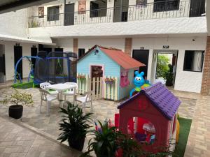 un'area giochi con una piccola casa e un parco giochi di Hotel Ozzy a Doradal