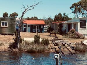 a group of houses and a body of water at The Artists Cottage - absolute waterfront in Strahan