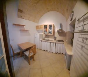 a kitchen with a table and a sink and a stove at Domus Astra in Brindisi