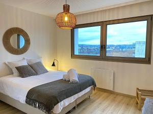 アヌシーにあるLE PANORAMIQUEのベッドと大きな窓のある寝室