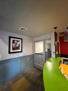 a living room with a green couch and a window at Chateau Suites in Norristown