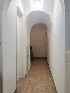 a hallway with an archway and a tile floor at Évora Romana Alojamentos T2 Aqueduto in Évora