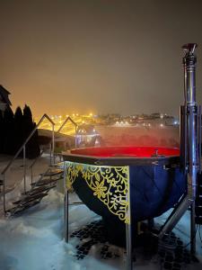 un bain à remous dans la neige la nuit dans l'établissement Apartamenty Liliowe SPA & Wellness, à Murzasichle