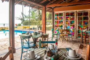 a room with a table and chairs and a pool at O Costão do Sol in Balneário Camboriú