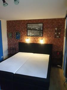 a bed in a room with a brick wall at Chalet am IJsselstrand in Doesburg