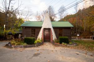 a small cabin with a green roof and a door at Qualla Cabins and Motel Cherokee near Casino in Whittier