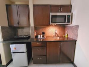 eine kleine Küche mit einer Spüle und einer Mikrowelle in der Unterkunft Royal Lodge in Edmonton