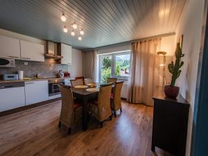 cocina y comedor con mesa y sillas en ERZHAUS Apartments en Eisenerz