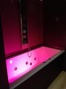 una vasca rosa con illuminazione rosa in bagno di Attico e super Attico vista mare a Montesilvano