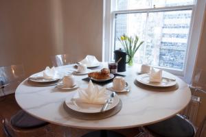 a table with plates and napkins on top of it at Merrythought Cottage - entire 2 bed, 2 bath cottage in the heart of Rye citadel in Rye